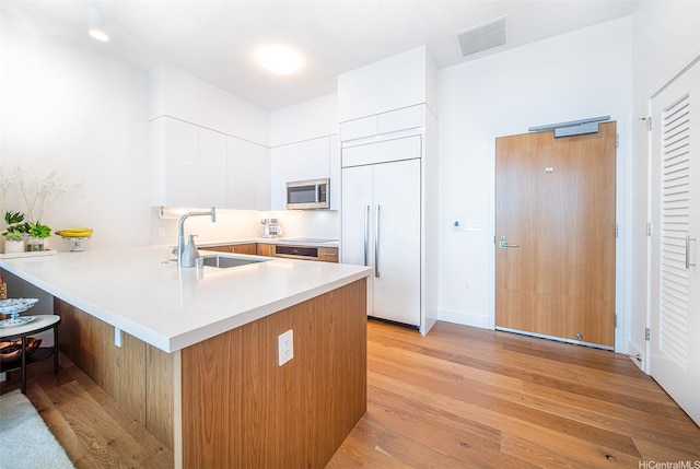 629 Keeaumoku St Unit 4108, Honolulu, HI 96814 - kitchen with stainless steel microwave, a sink, paneled built in refrigerator, a peninsula, and modern cabinets