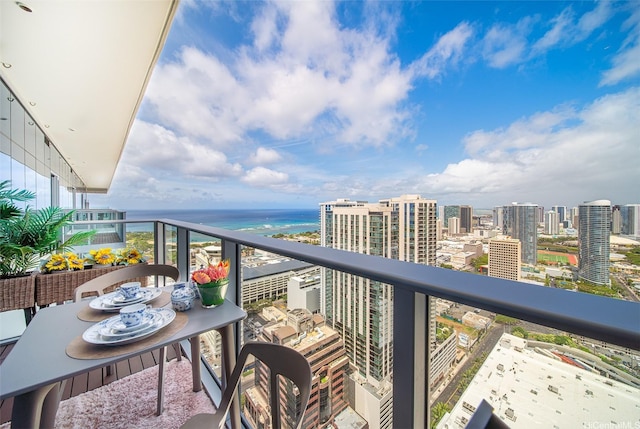 balcony with a water view and a view of city