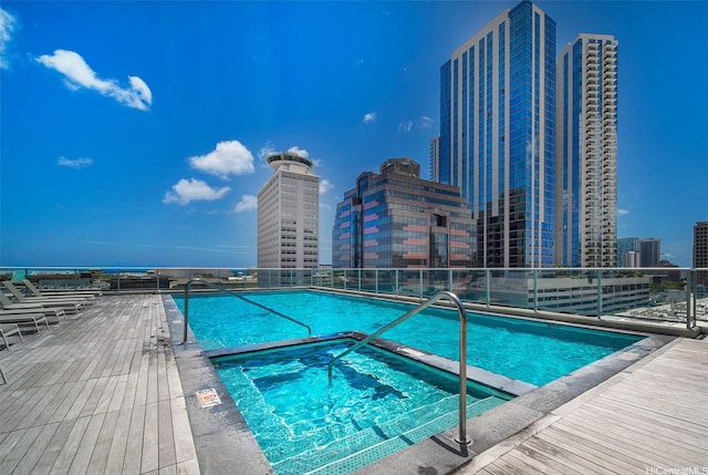 community pool with a community hot tub and a view of city