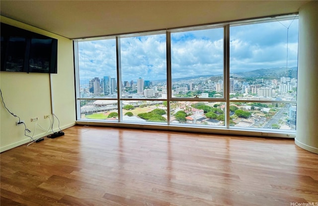 interior space featuring a city view, baseboards, and wood finished floors