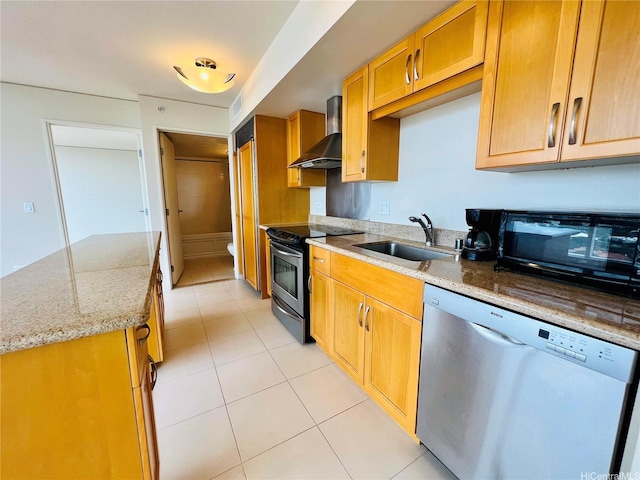 kitchen featuring visible vents, wall chimney range hood, light tile patterned floors, a sink, and appliances with stainless steel finishes
