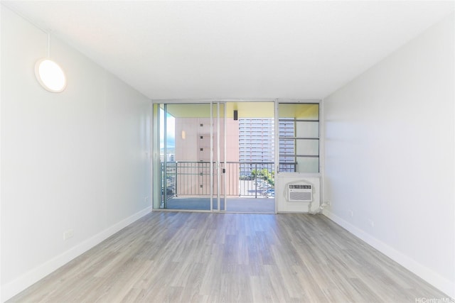 3161 Ala Ilima St Unit 403, Honolulu, HI 96818 - empty room featuring floor to ceiling windows, wood finished floors, baseboards, and a wall unit AC