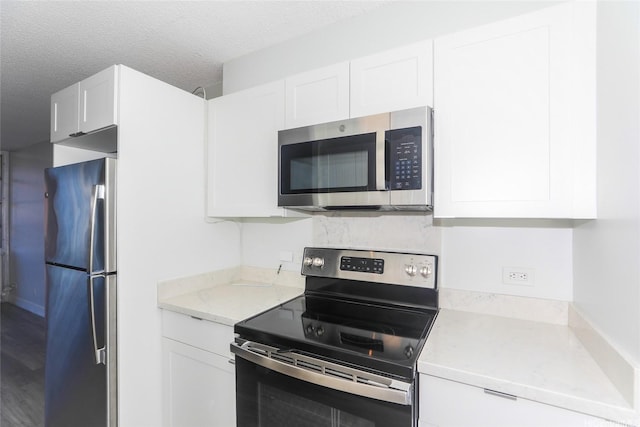 3161 Ala Ilima St Unit 403, Honolulu, HI 96818 - kitchen featuring light countertops, a textured ceiling, white cabinetry, and appliances with stainless steel finishes