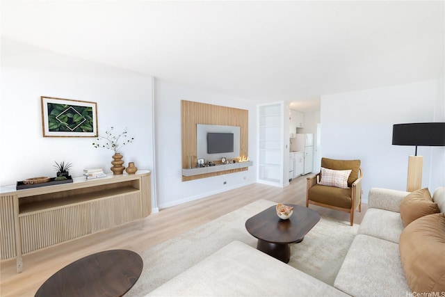 living area featuring wood finished floors and built in shelves