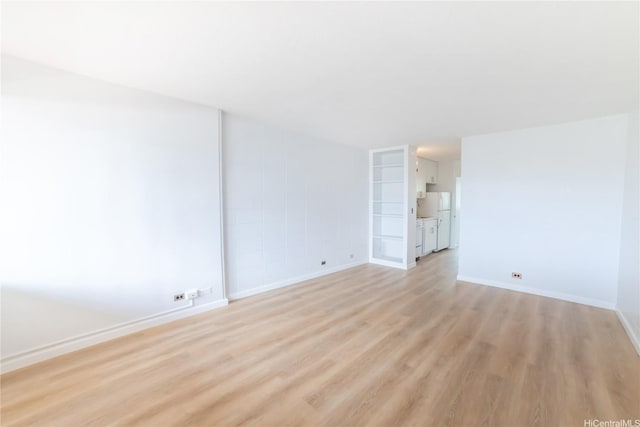 unfurnished room featuring light wood-style flooring and baseboards