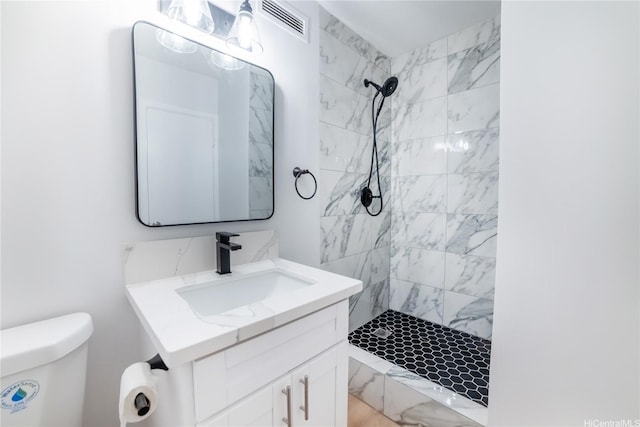 full bath featuring visible vents, toilet, vanity, and a stall shower