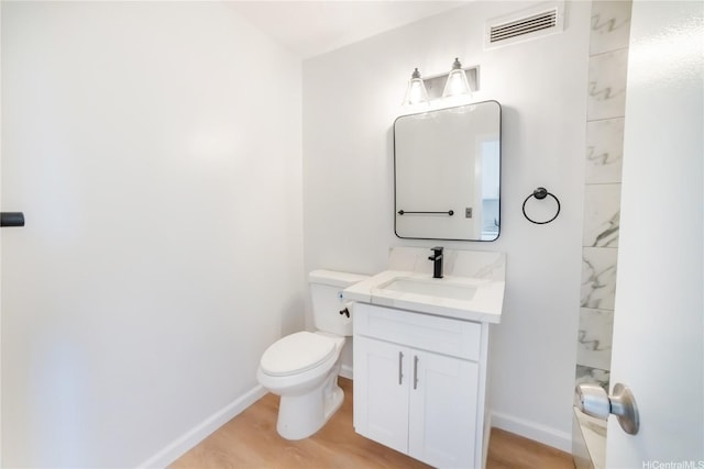 bathroom featuring baseboards, visible vents, toilet, and vanity