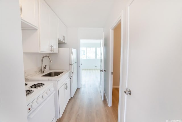 kitchen featuring white cabinets, light countertops, a sink, white electric range oven, and light wood-style floors