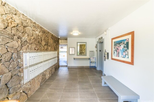 corridor with tile patterned flooring, elevator, and mail area
