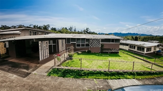 95-059 Waihonu St, Mililani, HI 96789 - back of house with a mountain view, a yard, concrete driveway, an attached carport, and a fenced backyard