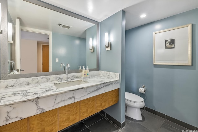bathroom featuring toilet, baseboards, vanity, and tile patterned floors