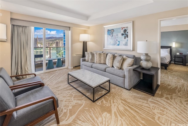 living room with carpet floors and a tray ceiling