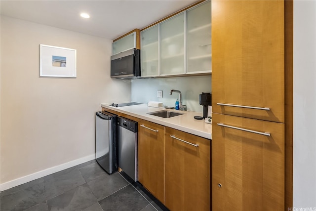 kitchen with stainless steel appliances, a sink, baseboards, light countertops, and glass insert cabinets