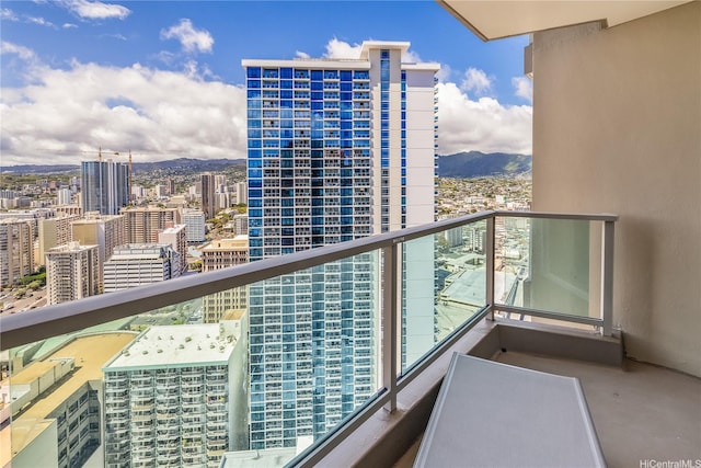 balcony featuring a mountain view and a city view