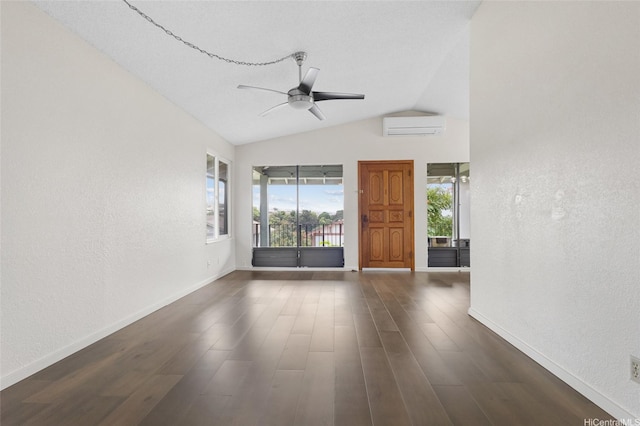 unfurnished living room with a textured wall, a ceiling fan, baseboards, and a wall unit AC