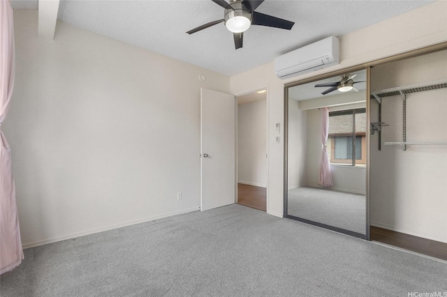 unfurnished bedroom with a ceiling fan, carpet floors, a wall mounted AC, and a closet