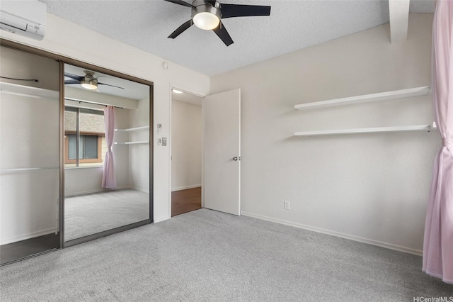 unfurnished bedroom with carpet flooring, ceiling fan, a textured ceiling, baseboards, and a closet