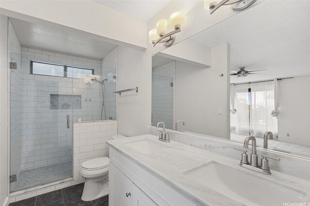 bathroom featuring toilet, a textured ceiling, a sink, and tile patterned floors