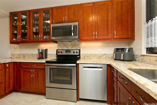 521 Hahaione St Unit 2-6J, Honolulu, HI 96825 - kitchen with stainless steel appliances, light stone countertops, decorative backsplash, and glass insert cabinets