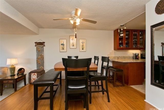 521 Hahaione St Unit 2-6J, Honolulu, HI 96825 - dining room featuring light wood-type flooring, a textured ceiling, ceiling fan, and indoor wet bar