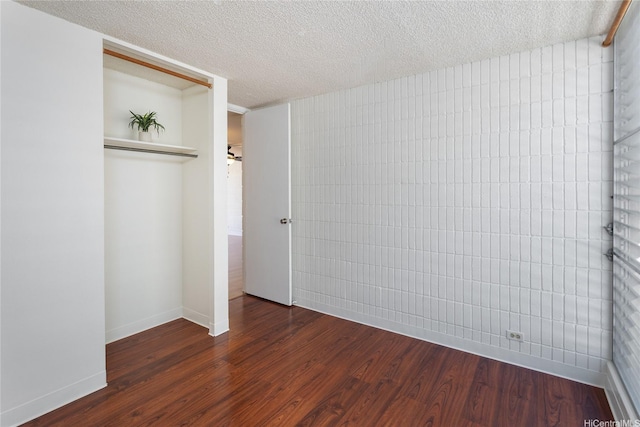 1524 Pensacola St Unit 217, Honolulu, HI 96822 - unfurnished bedroom featuring dark wood-style flooring, a closet, and a textured ceiling