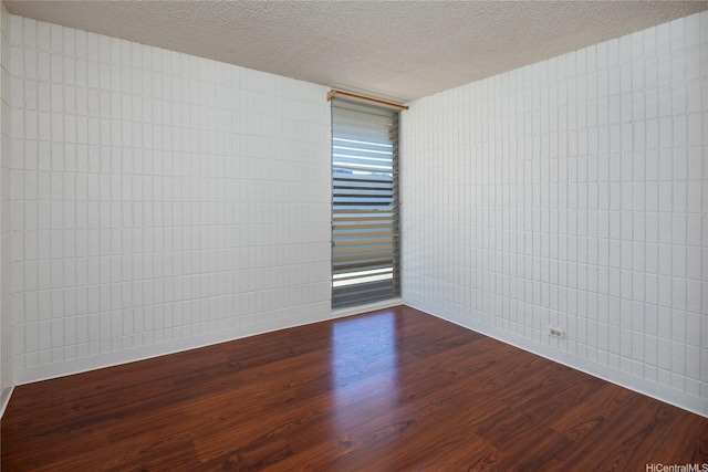 1524 Pensacola St Unit 217, Honolulu, HI 96822 - empty room featuring dark wood-style flooring and a textured ceiling