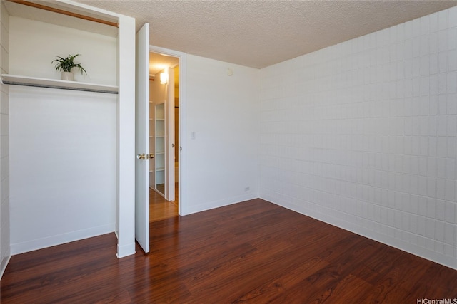 1524 Pensacola St Unit 217, Honolulu, HI 96822 - unfurnished bedroom featuring dark wood finished floors, a textured ceiling, and a closet