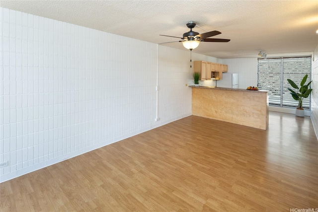 1524 Pensacola St Unit 217, Honolulu, HI 96822 - unfurnished living room with light wood-type flooring, a textured ceiling, and ceiling fan