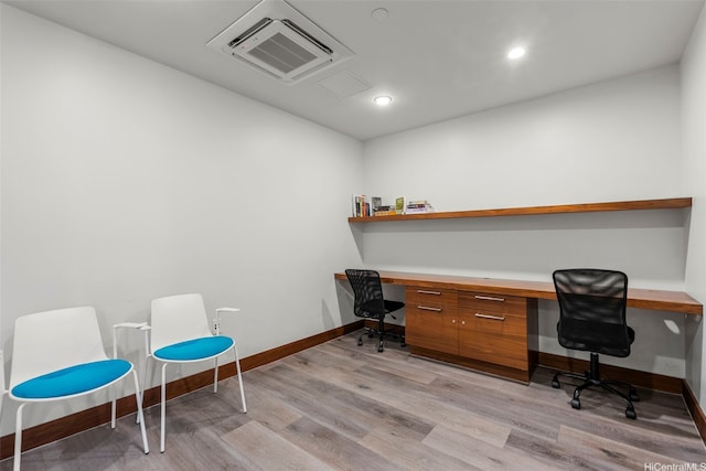 office featuring recessed lighting, baseboards, light wood finished floors, and built in desk