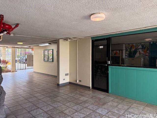 spare room with baseboards and a textured ceiling