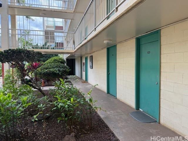 entrance to property featuring concrete block siding and a balcony