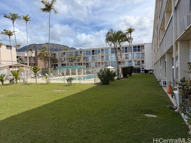surrounding community featuring fence, a lawn, and a pool