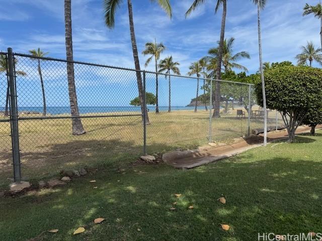 view of community featuring fence and a yard