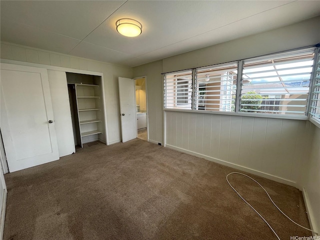 unfurnished bedroom featuring baseboards, a closet, and carpet