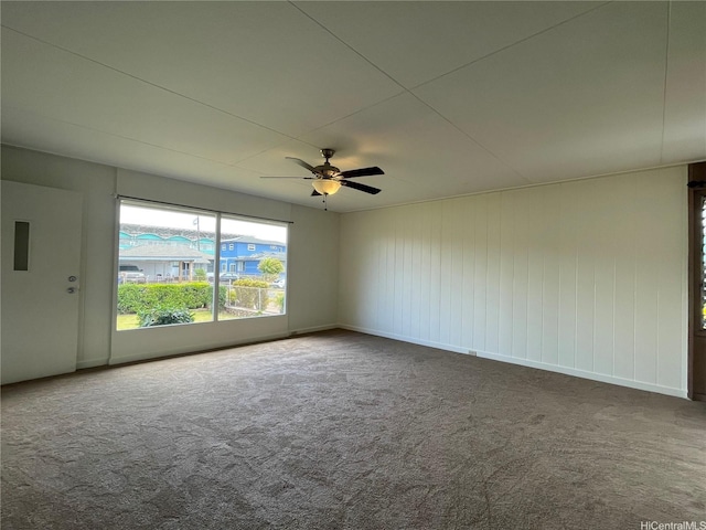 carpeted empty room with a ceiling fan and baseboards