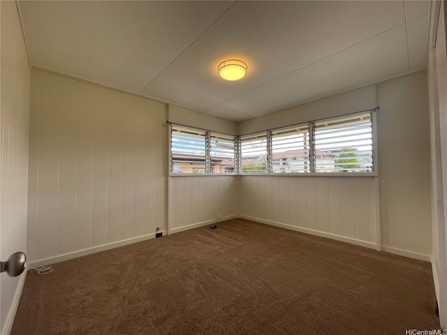 carpeted empty room featuring baseboards