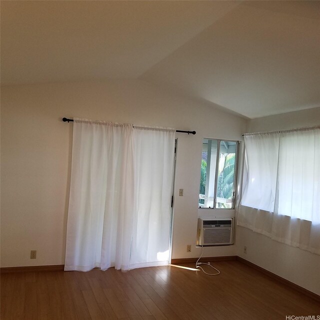 95-660 Wikao St Unit K206, Mililani, HI 96789 - empty room featuring baseboards, a wall mounted air conditioner, wood finished floors, and vaulted ceiling