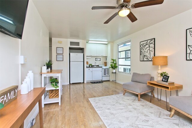 445 Kaiolu St Unit 211, Honolulu, HI 96815 - living area featuring light wood finished floors, a ceiling fan, and baseboards