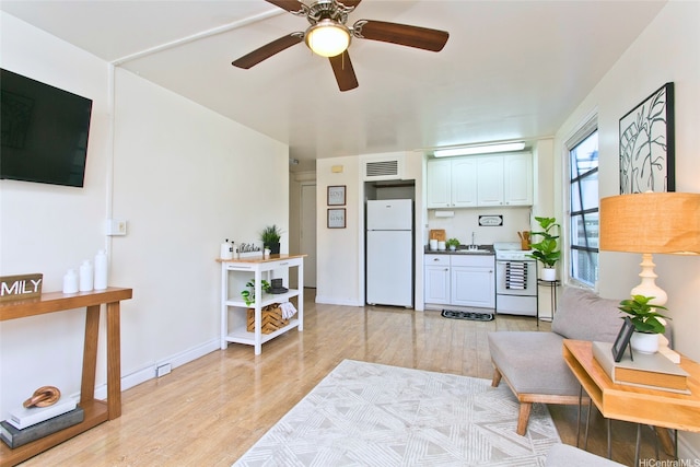 445 Kaiolu St Unit 211, Honolulu, HI 96815 - living area featuring light wood-style floors, ceiling fan, and baseboards
