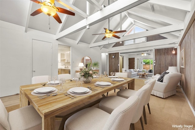 dining space with beamed ceiling, a ceiling fan, and high vaulted ceiling