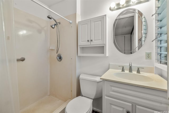 full bathroom featuring vanity, a shower stall, and toilet