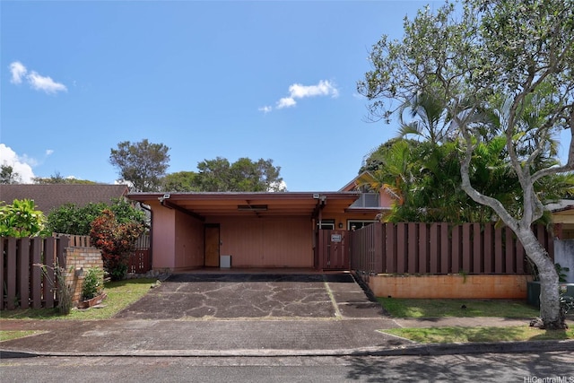 view of front facade featuring aphalt driveway, an attached carport, and fence private yard