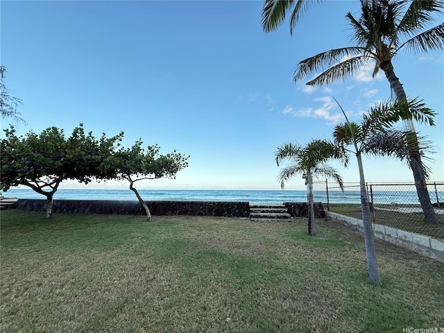 view of yard featuring fence and a water view