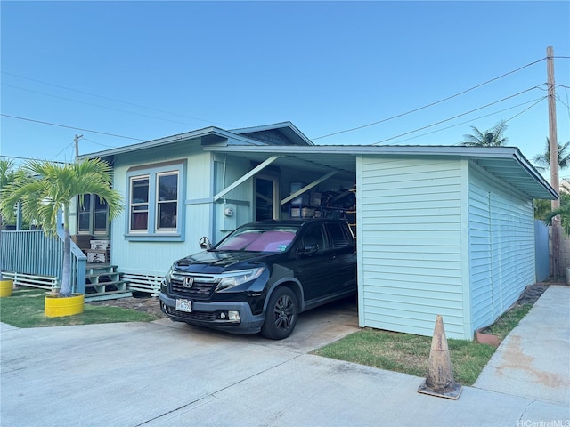 view of side of property with an attached carport and concrete driveway
