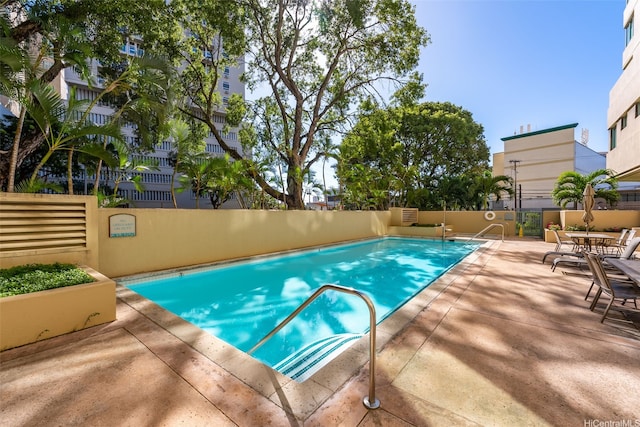community pool with fence and a patio