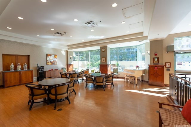 dining room with light wood-type flooring, visible vents, recessed lighting, and a tray ceiling
