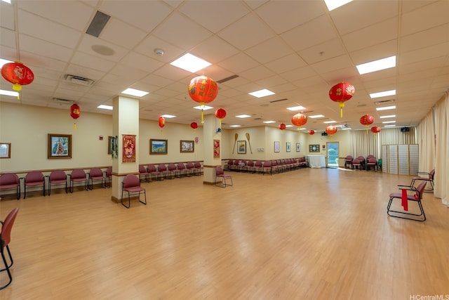 interior space featuring a paneled ceiling, visible vents, and wood finished floors