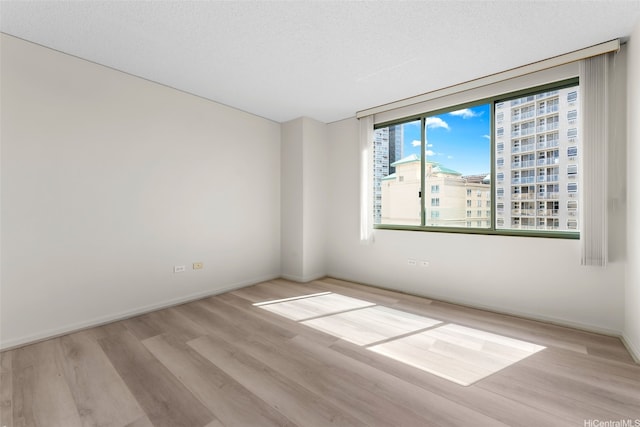 spare room featuring wood finished floors and baseboards