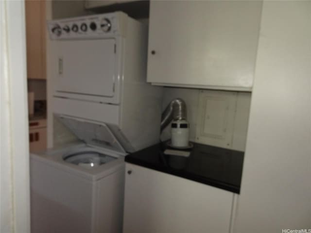 clothes washing area with stacked washer / drying machine and laundry area