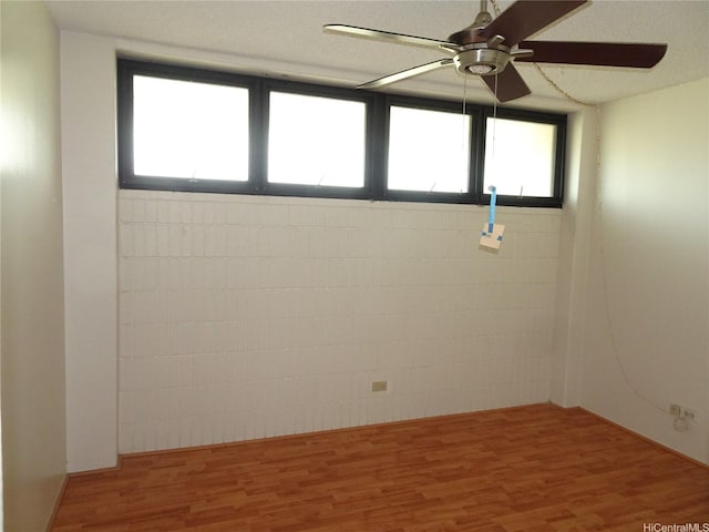 empty room featuring a ceiling fan and wood finished floors